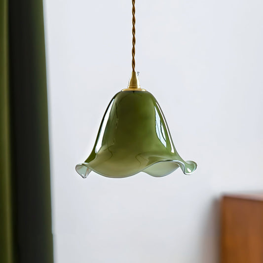 Green pendant light hanging against a white wall