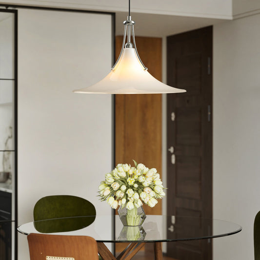 Pendant light fixture hanging above a glass dining table with a vase of flowers.