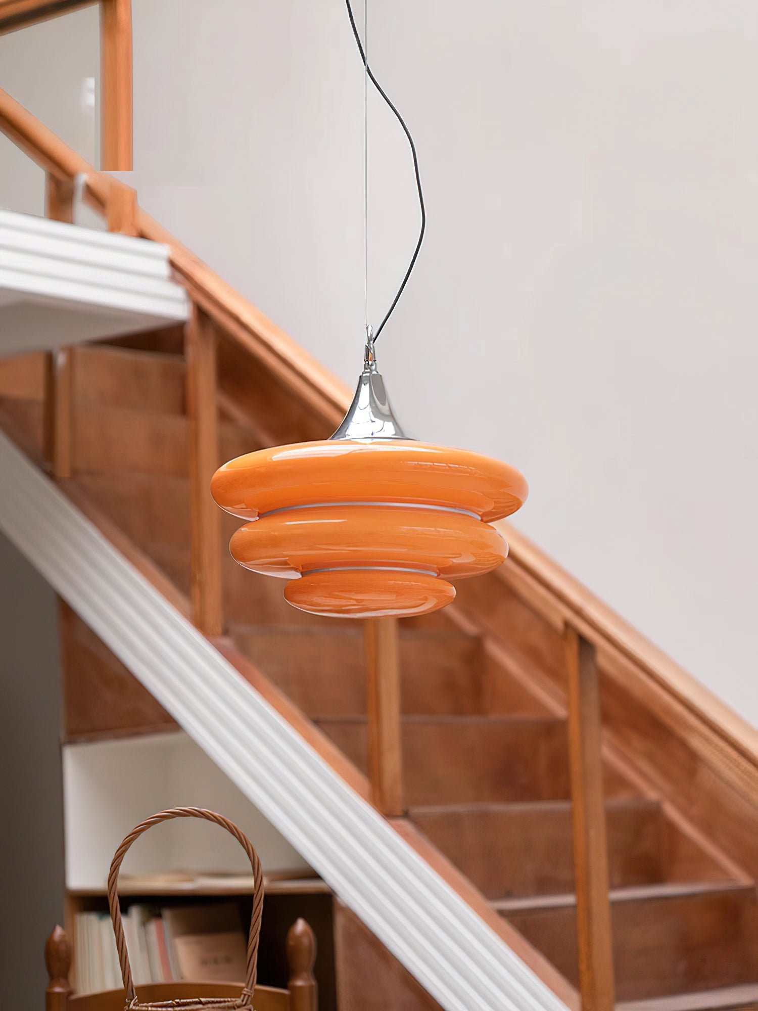 Orange pendant light hanging above a staircase