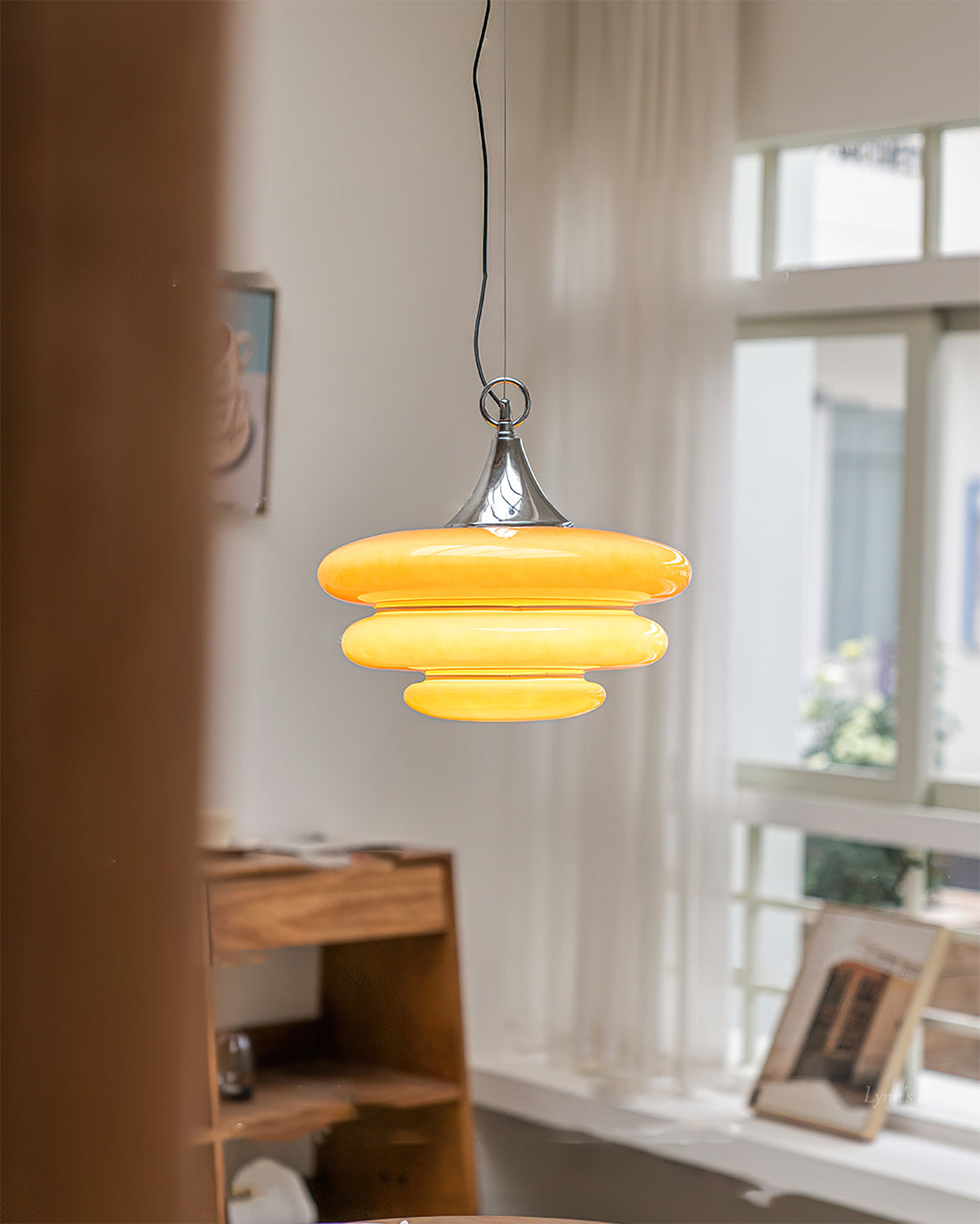 Yellow pendant light hanging in a room with a desk and window