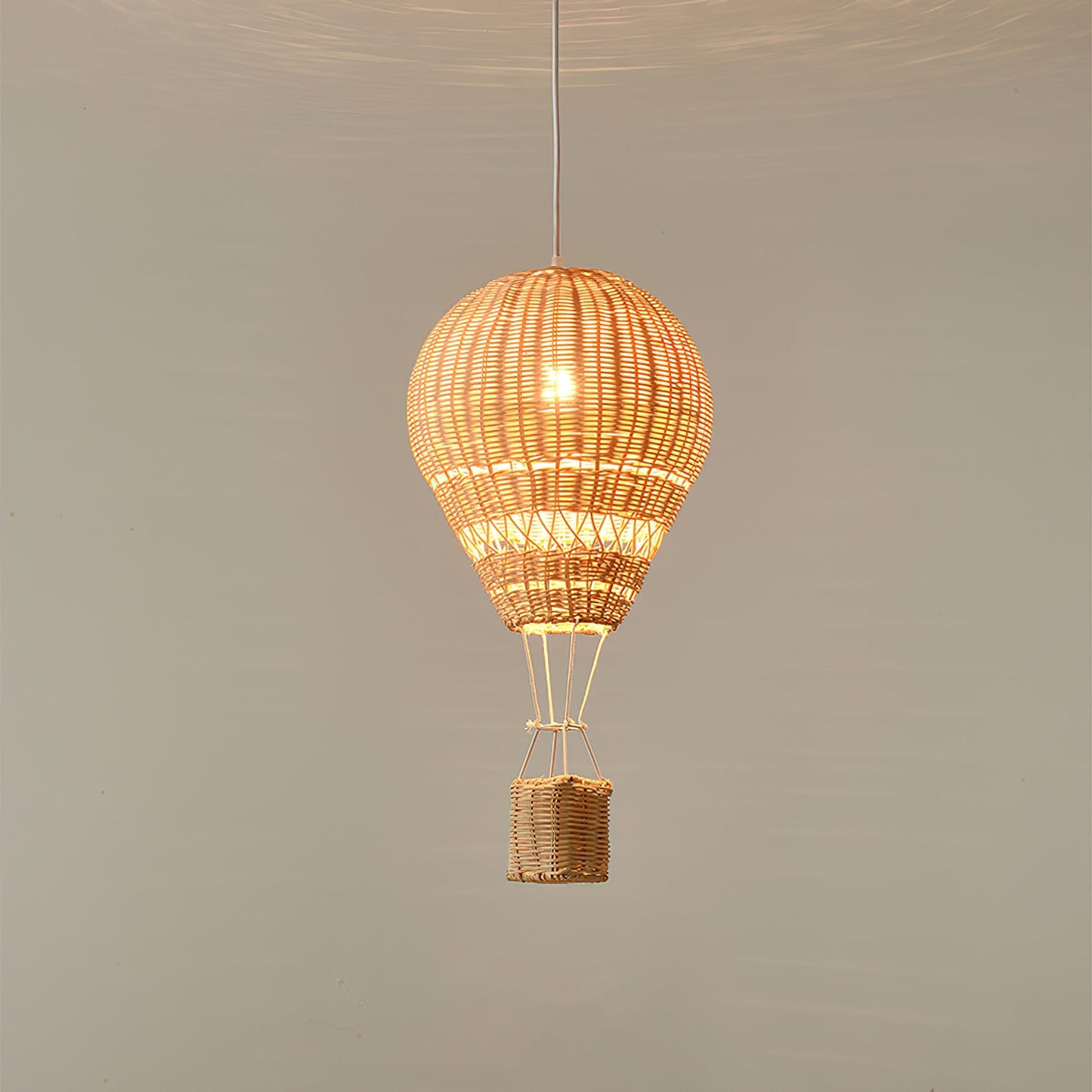 Wicker hot air balloon lamp hanging against a plain background