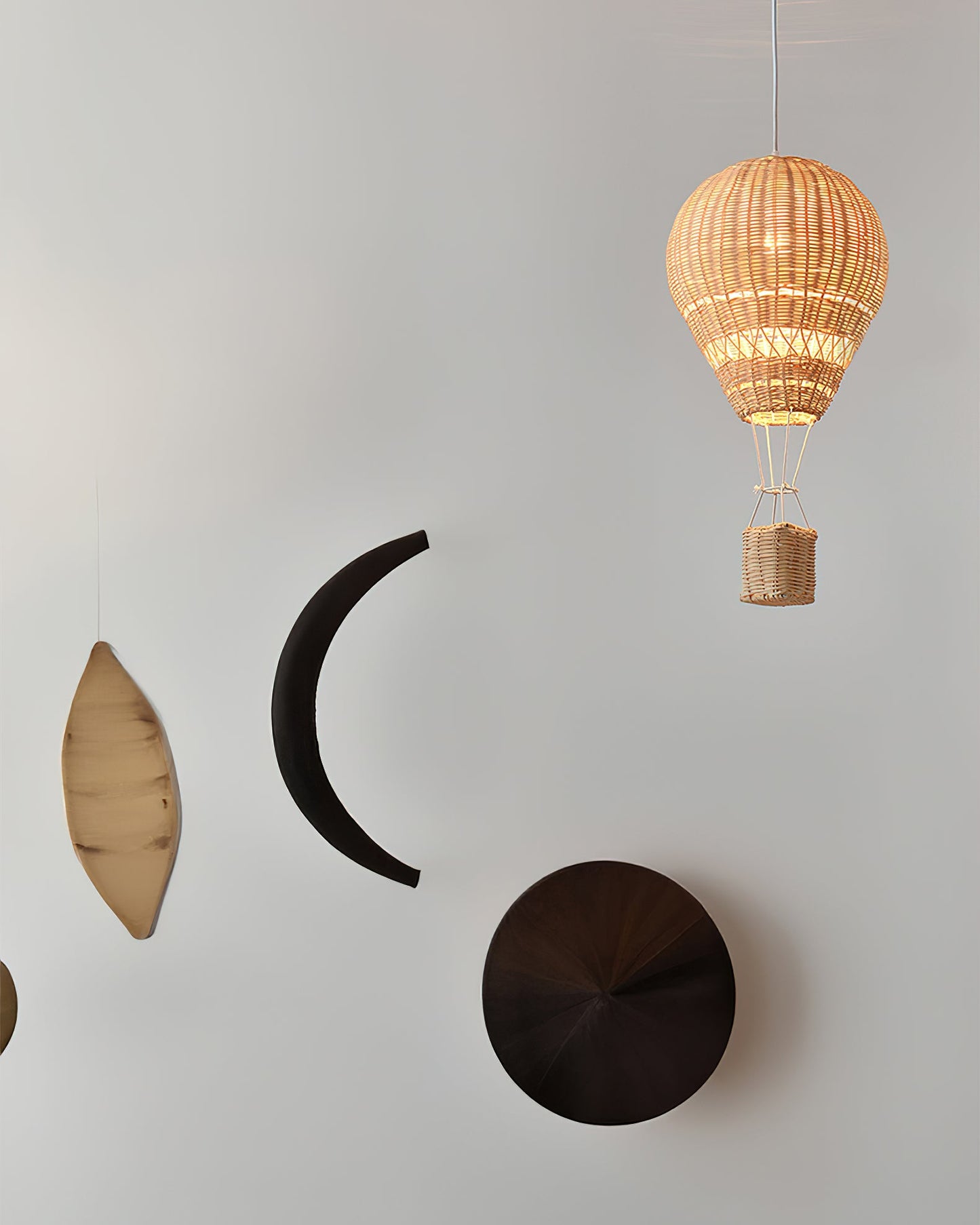 Decorative wall art with a wicker hot air balloon and geometric shapes on a light gray background
