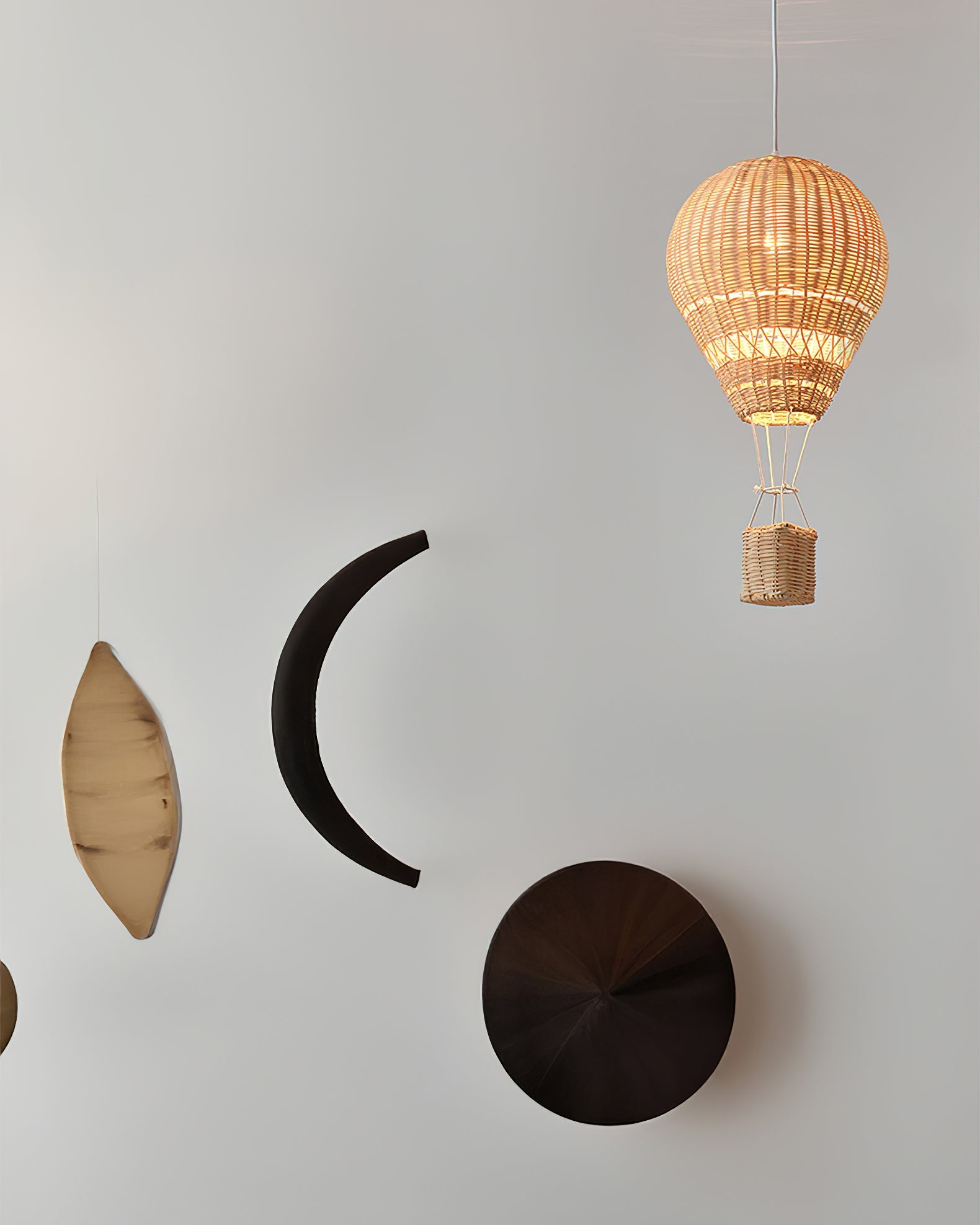 Decorative wall art with a wicker hot air balloon and geometric shapes on a light gray background