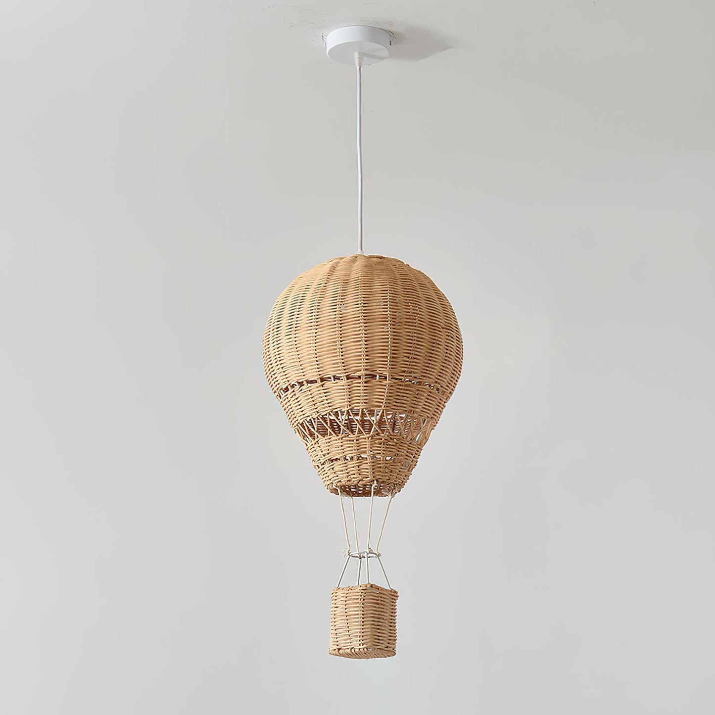Wicker hot air balloon pendant light on a plain background